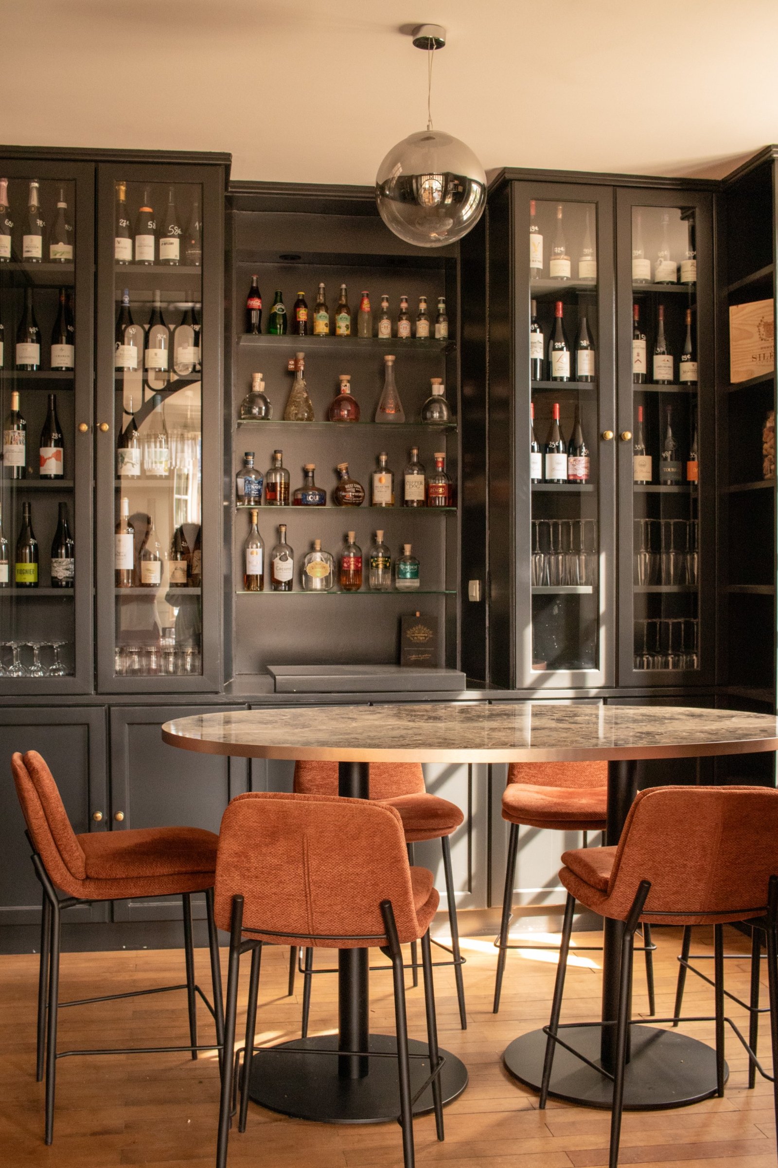 Dark hospitality bar with rust-coloured seating and warm natural light