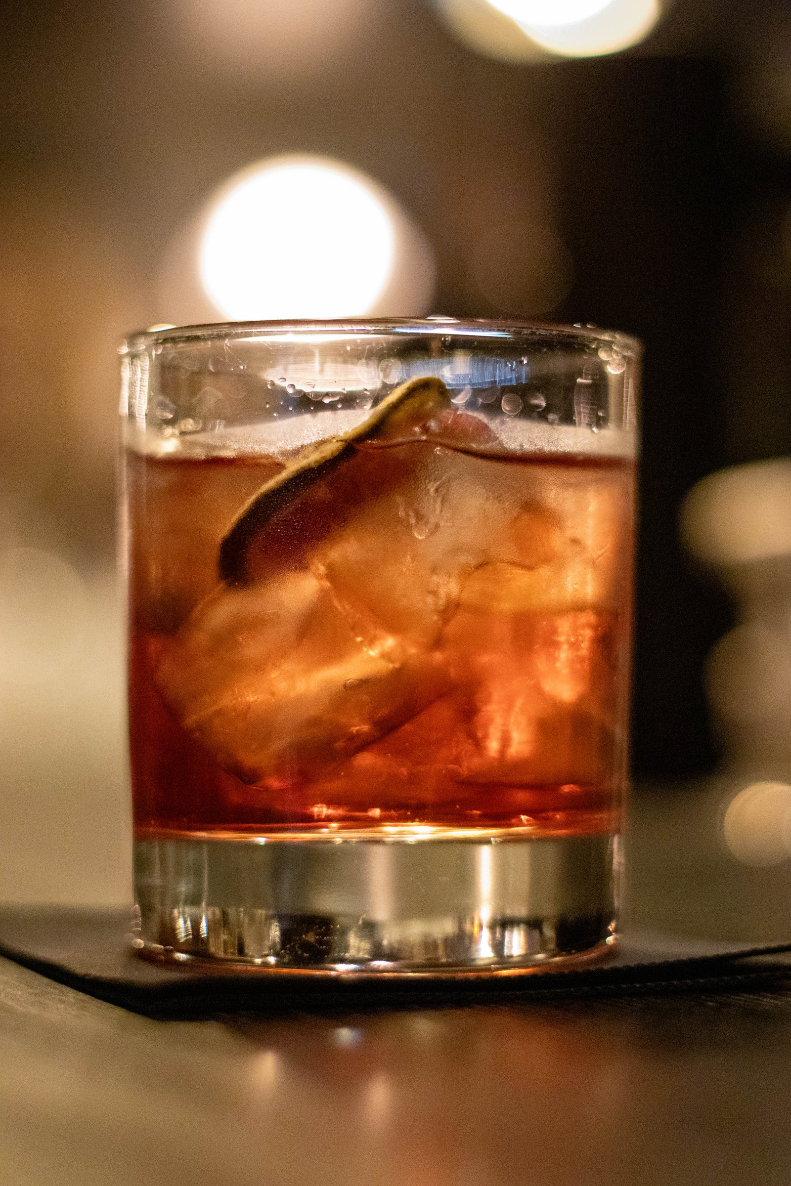 Amber-toned drink over ice, glowing in low evening light